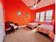 Comfortable bedroom featuring two twin beds, vibrant wall color, and ceiling fan at 9594 Doubloon Trl, Placida, FL 33946