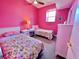 Cozy bedroom with two twin beds, a ceiling fan, and a window offering natural light at 9594 Doubloon Trl, Placida, FL 33946