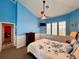 Bedroom featuring a view of a living space, white wainscotting, blue paint and ceiling fan at 9594 Doubloon Trl, Placida, FL 33946
