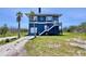 Beautiful coastal home boasting blue siding, a garage, an elevated deck, and complemented by tropical palm trees at 9594 Doubloon Trl, Placida, FL 33946