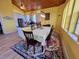 Open-concept kitchen and dining area with stainless appliances, wood ceiling, and decorative rug at 9594 Doubloon Trl, Placida, FL 33946