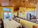Open-concept kitchen and living space with stainless steel appliances, breakfast bar, and wood ceiling at 9594 Doubloon Trl, Placida, FL 33946