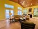 Spacious living room with high wood ceilings, fireplace, and views from the French doors at 9594 Doubloon Trl, Placida, FL 33946