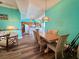 Bright, open-concept living area with laminate floors seamlessly connecting the dining space to the kitchen at 9594 Doubloon Trl, Placida, FL 33946