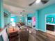 Wide-angle view of living room with aqua walls leading to dining area, bedroom, and bathroom at 9594 Doubloon Trl, Placida, FL 33946