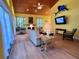 Inviting living room with wood ceilings, fireplace, and cozy rocking chair near leafy curtains at 9594 Doubloon Trl, Placida, FL 33946