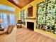 Cozy living room with a fireplace, hardwood floors, and leafy patterned curtains, offering a relaxing ambiance at 9594 Doubloon Trl, Placida, FL 33946