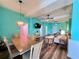 Open-concept living and dining area with aqua walls, modern furniture, and ample lighting at 9594 Doubloon Trl, Placida, FL 33946