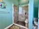 Bathroom shower featuring pebbled floor, shower seat, tiled walls, and glass doors at 9594 Doubloon Trl, Placida, FL 33946