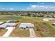Aerial view of charming single-story home on a golf course with a long driveway and mature landscaping at 11 Oakland Hills Rd, Rotonda West, FL 33947