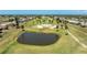 Beautiful aerial view of a golf course community, with mature trees and a large pond in the foreground at 11 Oakland Hills Rd, Rotonda West, FL 33947