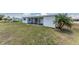 Back exterior showing a covered patio and well maintained lawn at 11 Oakland Hills Rd, Rotonda West, FL 33947