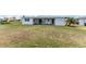 Back exterior with a covered patio and a well maintained lawn at 11 Oakland Hills Rd, Rotonda West, FL 33947