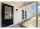 Close up of front door with decorative glass, exterior light fixture, and view of two-car garage at 11 Oakland Hills Rd, Rotonda West, FL 33947