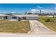 Front exterior with a 2 car garage and a long driveway at 11 Oakland Hills Rd, Rotonda West, FL 33947