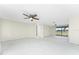 Spacious living room with ceiling fan, access to the backyard, and neutral-colored walls and flooring at 11 Oakland Hills Rd, Rotonda West, FL 33947