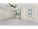 Bright living room featuring neutral paint, modern ceiling fan, window with backyard views, and exterior door at 11 Oakland Hills Rd, Rotonda West, FL 33947