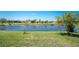 Lush green lawn slopes towards a serene lake, creating a tranquil and picturesque view at 1157 Rotonda Cir, Rotonda West, FL 33947