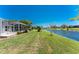 A well-manicured lawn slopes down to a tranquil lake, with a screened-in lanai visible at 1157 Rotonda Cir, Rotonda West, FL 33947