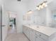 Bathroom with a white double sink vanity, tile flooring, and an open door to a bedroom at 1157 Rotonda Cir, Rotonda West, FL 33947