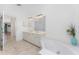 Bathroom with a white double sink vanity, a jacuzzi tub, and tile flooring at 1157 Rotonda Cir, Rotonda West, FL 33947