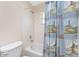 A bathroom featuring white tile, a shower/tub combination, and a blue shower curtain with nautical pattern at 1157 Rotonda Cir, Rotonda West, FL 33947