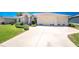Well-maintained home showcasing a spacious driveway and a manicured lawn at 1157 Rotonda Cir, Rotonda West, FL 33947