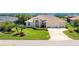 Inviting single-story home featuring a lush lawn, mature trees, and a spacious driveway at 1157 Rotonda Cir, Rotonda West, FL 33947