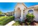 Inviting front entrance with manicured bushes and a columned covered porch at 1157 Rotonda Cir, Rotonda West, FL 33947