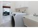 Laundry room features a white washer and dryer, storage cabinets, and a utility sink at 1157 Rotonda Cir, Rotonda West, FL 33947