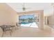 A covered lanai featuring comfortable seating with view of the screened pool and spa by the tranquil lake at 1157 Rotonda Cir, Rotonda West, FL 33947