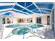 Screened-in pool area featuring a pool and jacuzzi with lanai looking into house at 1157 Rotonda Cir, Rotonda West, FL 33947
