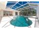 Screened-in pool area with a pool and jacuzzi as well as an attached lanai with outdoor seating at 1157 Rotonda Cir, Rotonda West, FL 33947