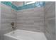 Close-up of the shower with gray tile and iridescent blue accents at 13344 Gershwin Ln, Port Charlotte, FL 33981