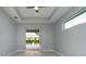This bedroom features a tray ceiling, modern ceiling fan, and views of the backyard pool at 13344 Gershwin Ln, Port Charlotte, FL 33981