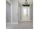Well-lit foyer featuring tiled flooring, a decorative light fixture, and a glass-paneled front door at 13344 Gershwin Ln, Port Charlotte, FL 33981