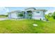 Well-maintained single-Gathering home features a two-car garage and a lush green lawn and tropical landscaping at 13344 Gershwin Ln, Port Charlotte, FL 33981