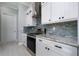 Close-up of kitchen featuring stainless steel range and hood with white cabinetry and granite countertops at 13344 Gershwin Ln, Port Charlotte, FL 33981