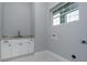 Functional laundry room features a sink, white cabinets, gray countertop, and a window for natural light at 13344 Gershwin Ln, Port Charlotte, FL 33981