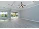 Spacious living room with a ceiling fan, recessed lighting, and sliding doors that open to a screened lanai and pool at 13344 Gershwin Ln, Port Charlotte, FL 33981