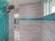 Walk-in shower with blue glass mosaic accents, rainfall showerhead, and a corner bench at 13344 Gershwin Ln, Port Charlotte, FL 33981