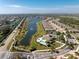 Aerial view of the community featuring a lake, pool, and clubhouse surrounded by lush landscaping and homes at 13392 Abercrombie Dr, Englewood, FL 34223