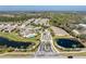 Aerial view of the community with clubhouse, pool, and lush landscaping nestled among scenic ponds and manicured lawns at 13392 Abercrombie Dr, Englewood, FL 34223