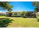 View of home's backyard, screened lanai, trimmed landscaping, and expansive lawn, ideal for outdoor enjoyment at 13392 Abercrombie Dr, Englewood, FL 34223