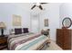 Neutral bedroom featuring a ceiling fan, neutral walls, striped bedspread and dresser at 13392 Abercrombie Dr, Englewood, FL 34223