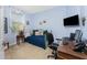 Bedroom with a small sofa, desk, and a mounted television perfect for a small office or guest room at 13392 Abercrombie Dr, Englewood, FL 34223