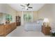 Bedroom with a ceiling fan, large window, and dressers at 13392 Abercrombie Dr, Englewood, FL 34223