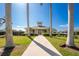 Clubhouse exterior with manicured lawn, sidewalk, and palm trees creating an inviting ambiance at 13392 Abercrombie Dr, Englewood, FL 34223
