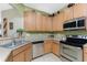 Kitchen with stainless steel appliances and light wood cabinets at 13392 Abercrombie Dr, Englewood, FL 34223