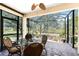 Enjoy this screened lanai with brick floor, ceiling fan, and outdoor views with dining table and chairs at 13392 Abercrombie Dr, Englewood, FL 34223